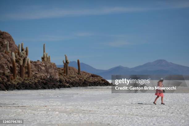 Woman wearing traditional clothes walks at salt flat during a mass wedding for 34 couples at Uyuni Salt Flats on May 20, 2022 in Uyuni, Bolivia. The...