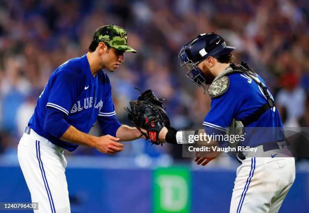 Jordan Romano of the Toronto Blue Jays celebrates the victory with catcher Danny Jansen following a MLB game against the Cincinnati Reds at Rogers...