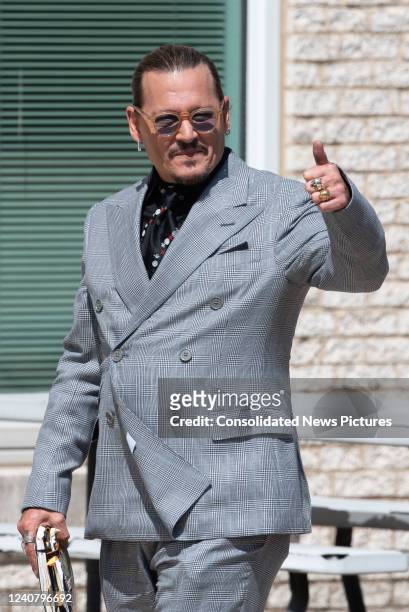 Johnny Depp gestures to fans during a break outside court during the Johnny Depp and Amber Heard civil trial at Fairfax County Circuit Court on May...