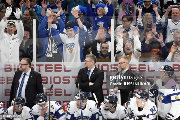 Finland's coach Kari Lehtonen, Jukka Jalonen and Mikko Manner stand behind players on the bench during the IIHF Ice Hockey World Championships 1st...