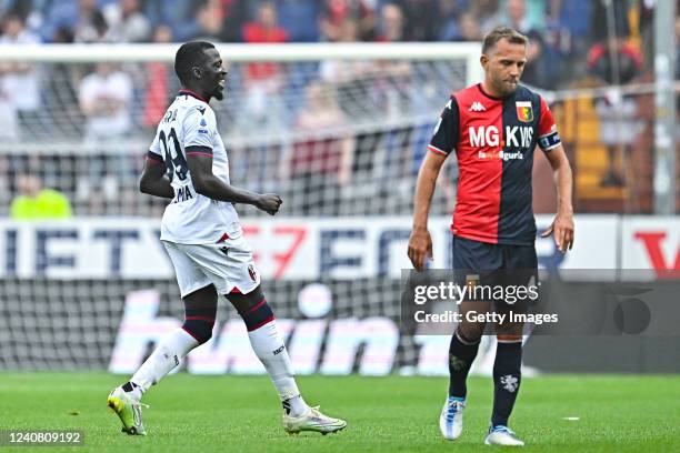 Musa Barrow of Bologna celebrates after scoring a goal as Domenico Criscito of Genoa reacts with disappointment during the Serie A match between...