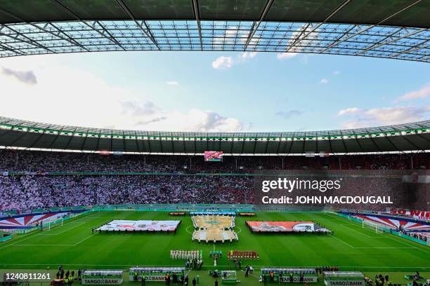 Teams line up for the national anthem prior to the German Cup final football match between SC Freiburg and RB Leipzig at the Olympic Stadium in...