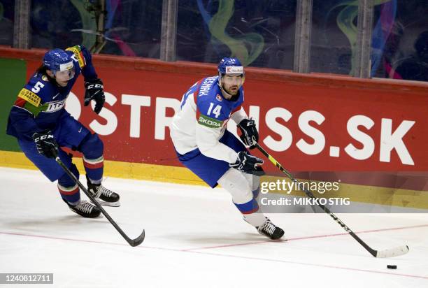 Italy's forward Marco Sanna and Slovakia's defender Peter Ceresnak vie for the puck during the 2022 IIHF Ice Hockey World Championships preliminary...