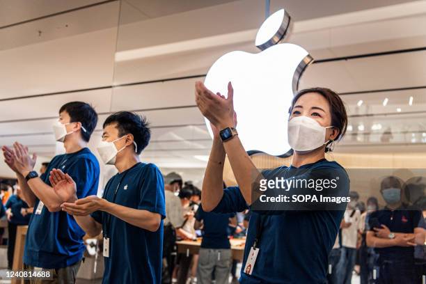Apple staff wearing masks welcome customers at the opening of a new store in Wuhan, China's Hubei province. Apple opened its first flagship store in...