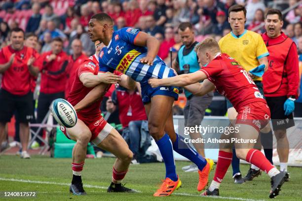 Tom Rogers and Sam Castelow of the Scarlets tackle Damian Willemse of Stomers during the United Rugby Championship match between the Scarlets and...