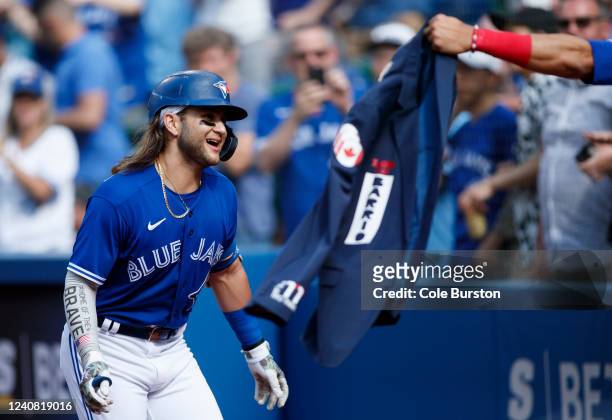 The Home Run celebration jacket is held out as Bo Bichette of the Toronto Blue Jays runs to the dugout to celebrate his two-run home run in the...