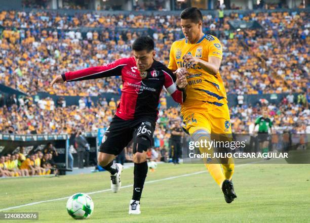 Hugo Ayala of Tigres vies for the ball with Aldo Rocha of Atlas during the Mexican Clausura 2022 tournament second leg semifinal football match at...