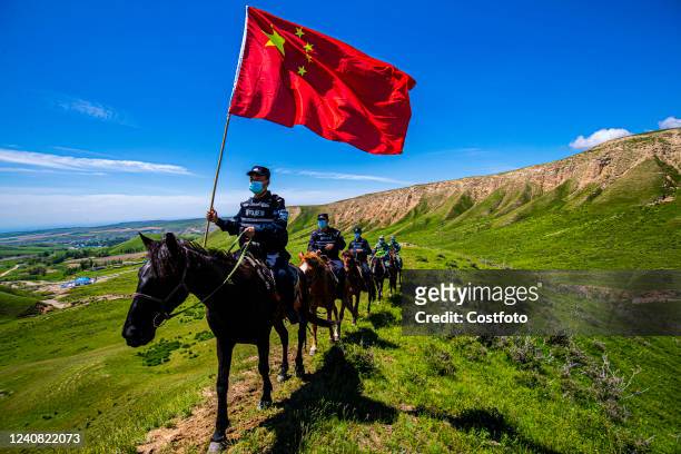 Police officers and border guards ride horses to patrol along the frontier pass in Zhili Prefecture, Xinjiang Province, China, May 20, 2022.