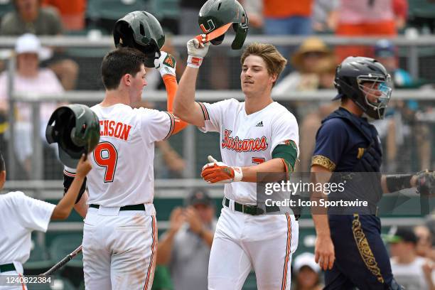 Miami outfielder Jacob Burke bumps helmets with outfielder Zach Levenson after hitting a solo home run in the fourth inning as the University of...