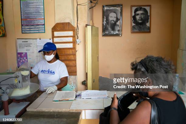 Marta Jorlen, left has been selling milk at state bodegas for 32 years. Isabel Ibanez right, gets a subsidized ration of milk as Cuban...