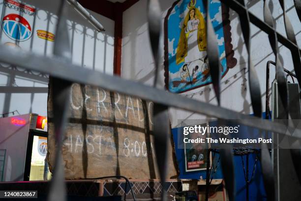 State run store near the Cuatro Caminos Market has a photo of Fidel Castro with a painting of La Caridad del Cobre, the patron saint of Cuba above....