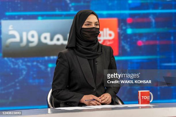 Female presenter for Tolo News, Sonia Niazi, covers her face in a live broadcast at Tolo TV station in Kabul on May 22, 2022. - Women presenters on...