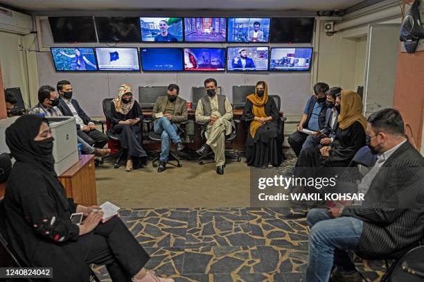 Reporters for Tolo News cover their faces as they attend an editorial meeting at Tolo TV station in Kabul on May 22, 2022. - Women presenters on...