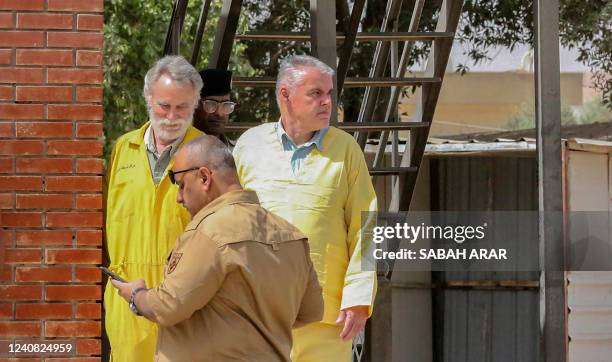 James Fitton a retired British geologist and Volker Waldmann a Berlin psychologist, are dressed in the yellow uniform of detainees as they are arrive...