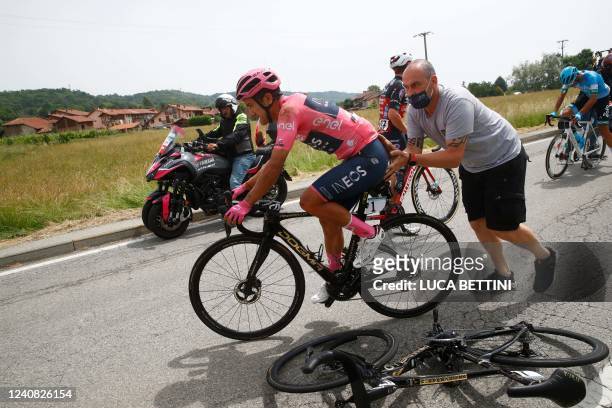 Overall leader Team Ineos' Ecuadorian rider Richard Carapaz is helped restart after a crash in the first kilometers of the 15th stage of the Giro...