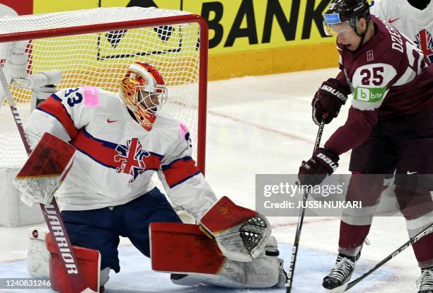 Great Britain's goalkeeper Ben Bowns defends the net against Latvia's forward Andris Dzerins during the IIHF Ice Hockey World Championships 1st Round...