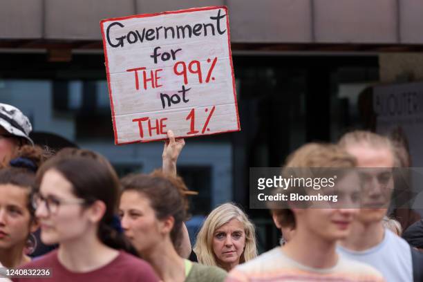 Protester holds a placard reading "Government for The 99% not The 1%" ahead of the World Economic Forum in Davos, Switzerland, on Sunday, May 22,...