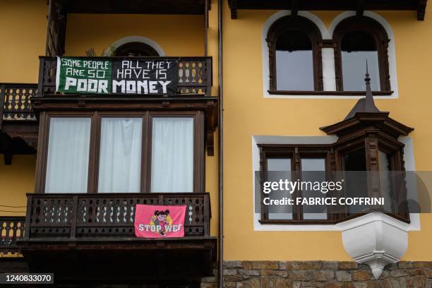 Banners against the World Economic Forum are seen on a house next to the Congress centre during the WEF annual meeting in Davos on May 22, 2022.