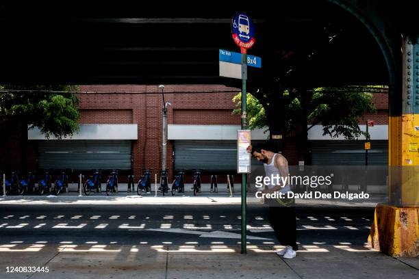 Person waits for the bus on May 22, 2022 in The Bronx borough of New York City. Temperatures in the metro area will surpass the 90 degree mark...