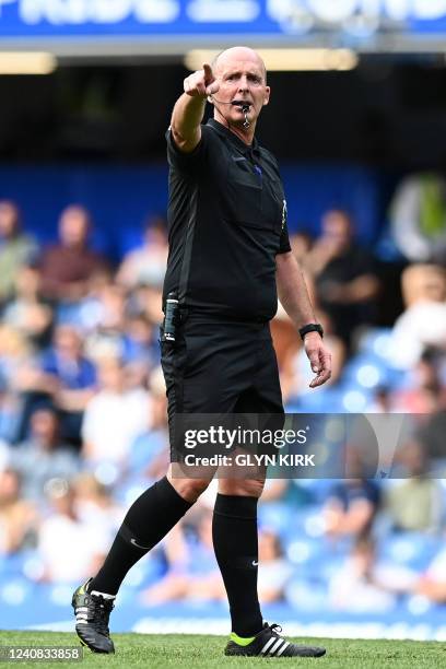 English referee Mike Dean gestures during the English Premier League football match between Chelsea and Watford at Stamford Bridge in London on May...