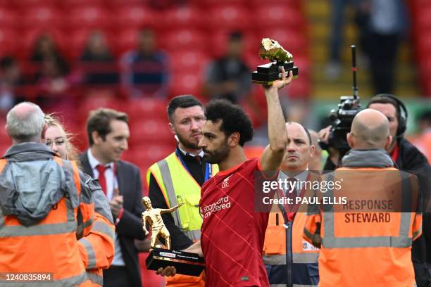 Liverpool's Egyptian midfielder Mohamed Salah celebrates with his two trophies "golden boot" and "playmaker of the year" at the end of the English...