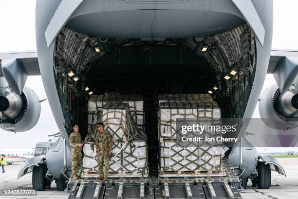 Airmen stand in the cargo bay of a U.S. Air Force C-17 carrying 78,000 lbs of Nestlé Health Science Alfamino Infant and Alfamino Junior formula from...