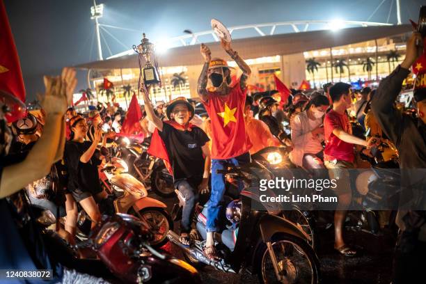 Football fans celebrate outside the My Dinh stadium as Vietnam successfully defended the SEA Games men's football gold medal after beating Thailand...