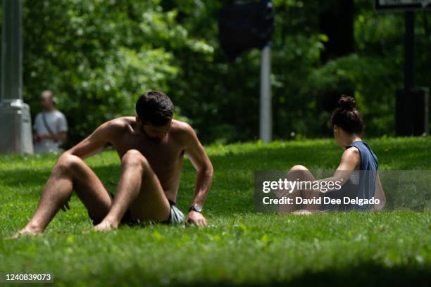 People sun bathe in Central Park on May 22, 2022 in New York City. Temperatures in the metro area will surpass the 90 degree mark prompting heat...