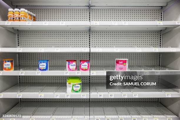 Shelves normally meant for baby formula sit nearly empty at a store in downtown Washington, DC, on May 22, 2022. - A US military plane bringing...