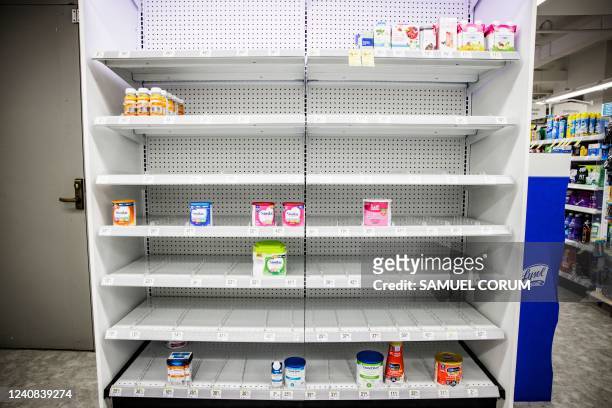 Shelves normally meant for baby formula sit nearly empty at a store in downtown Washington, DC, on May 22, 2022. - A US military plane bringing...
