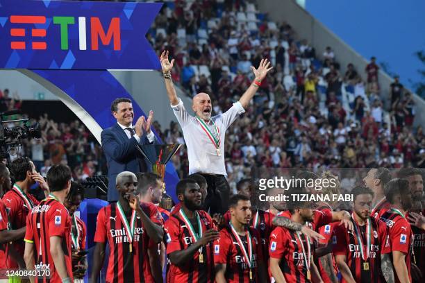 Milan's Italian head coach Stefano Pioli and AC Milan's players celebrate during the winner's trophy ceremony after AC Milan won the Italian Serie A...