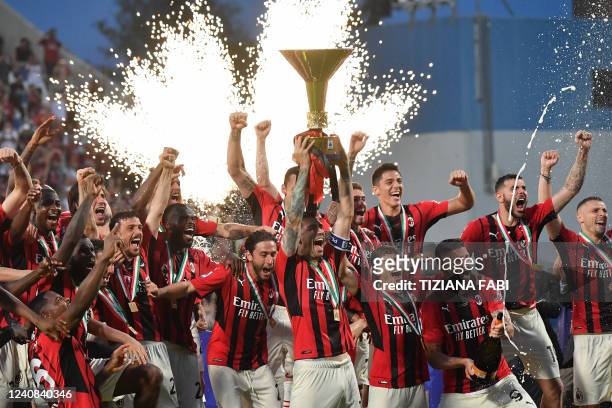 Milan's Italian defender Alessio Romagnoli and AC Milan's players celebrate with the winner's trophy after AC Milan won the Italian Serie A football...