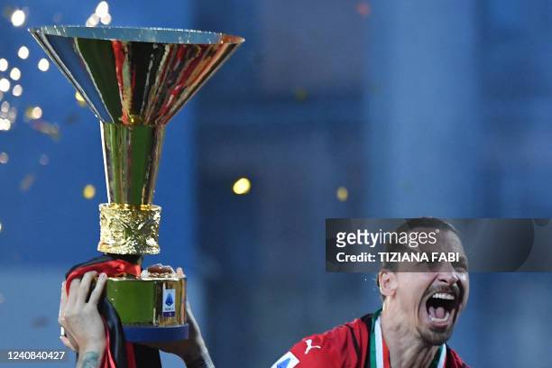 Milan's Swedish forward Zlatan Ibrahimovic and teammates celebrate with the winner's trophy after AC Milan won the Italian Serie A football match...