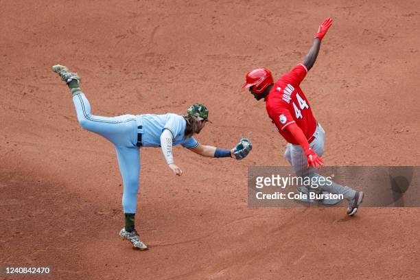 Bo Bichette of the Toronto Blue Jays misses the tag as Aristides Aquino of the Cincinnati Reds steals second base in the sixth inning of their MLB...