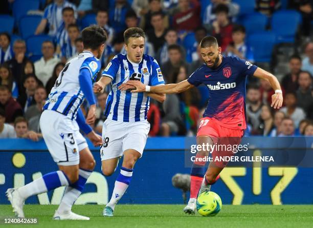 Atletico Madrid's Belgian midfielder Yannick Ferreira-Carrasco fights for the ball with Real Sociedad's Spanish defender Andoni Gorosabel and Real...