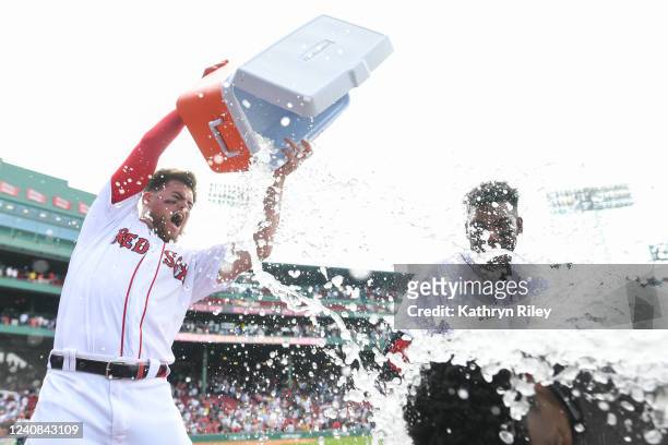 Christian Arroyo of the Boston Red Sox dumps water on Franchy Cordero after Cordero hit a walk-off grand slam in the tenth inning against the Seattle...