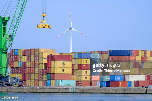 Crane, ocean containers and a windmill are seen from the Kanaaldock B1 during a visit of the 'Port of Antwerp-Bruges on April 28, 2022 in Antwerp,...