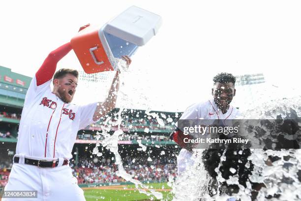 Christian Arroyo of the Boston Red Sox dumps water on Franchy Cordero after Cordero hit a walk-off grand slam in the tenth inning against the Seattle...