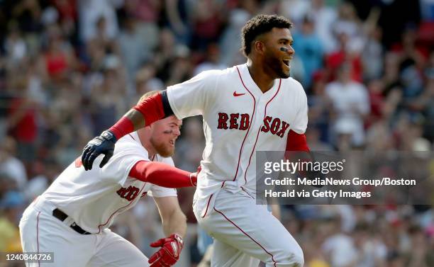 Boston Red Sox's Franchy Cordero is mobbed by his teammates including Christian Arroyo after hitting a walk off grand slam during the 10th inning of...