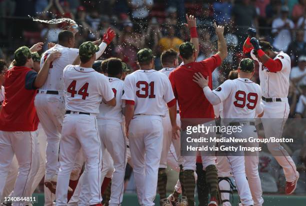 Boston Red Sox's Franchy Cordero is mobbed by his teammates after hitting a walk off grand slam during the 10th inning of the game against the...