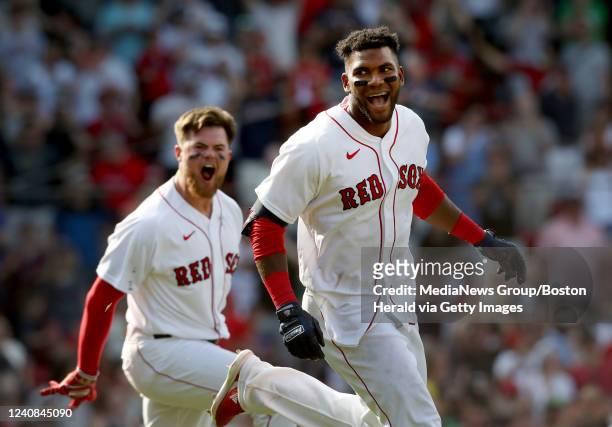 Boston Red Sox's Franchy Cordero is mobbed by his teammates including Christian Arroyo after hitting a walk off grand slam during the 10th inning of...