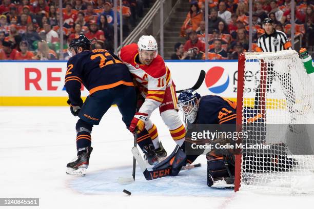 Goaltender Mike Smith of the Edmonton Oilers makes a save against Mikael Backlund of the Calgary Flames during the first period in Game Three of the...