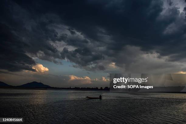 Boatman rows his boat across the Dal lake during a cloudy evening in Srinagar. Weather remains partly cloudy with Meteorological Department forecast...