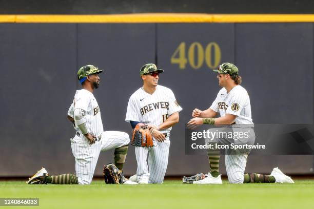 Milwaukee Brewers left fielder Andrew McCutchen , center fielder Tyrone Taylor , and right fielder Hunter Renfroe have a conference during a pitching...