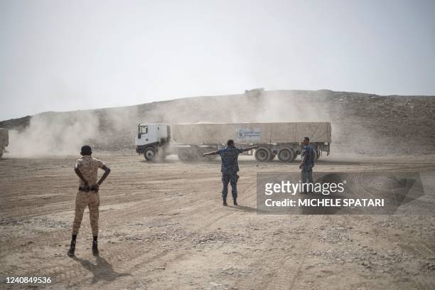 Members of the Ethiopia Federal Police and Afar Police usher a truck to stop at a security checkpoint where a 130 trucks aid convoy directed to...