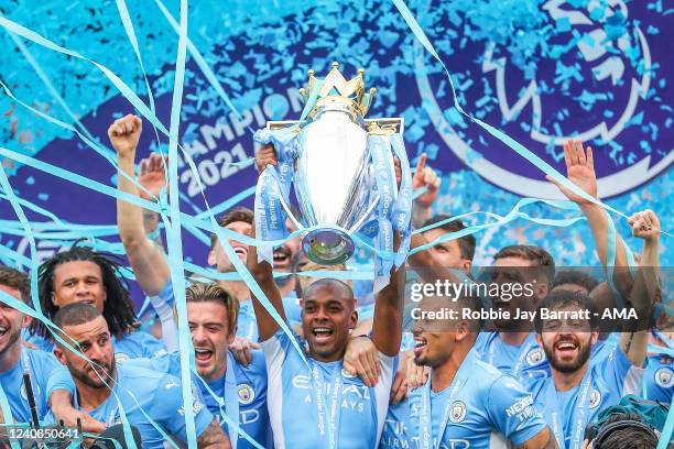 Fernandinho of Manchester City celebrates winning the Premier League by lifting the trophy with his team mates during the Premier League match...