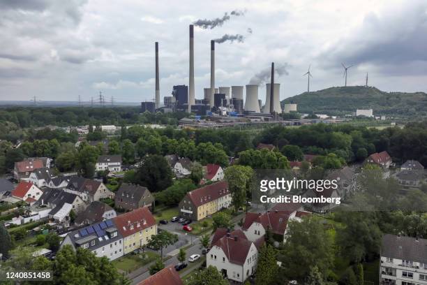 Chimneys and a cooling tower emit vapor at the Scholven coal-fired power plant, operated by Uniper SE, beyond housing in Gelsenkirchen, Germany, on...