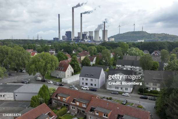 Chimneys and a cooling tower emit vapor at the Scholven coal-fired power plant, operated by Uniper SE, beyond housing in Gelsenkirchen, Germany, on...