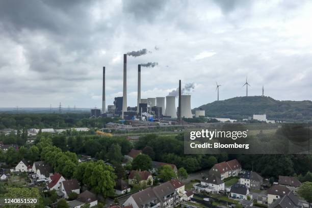 Chimneys and a cooling tower emit vapor at the Scholven coal-fired power plant, operated by Uniper SE, beyond housing in Gelsenkirchen, Germany, on...