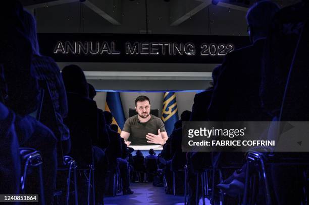 Ukrainian President Volodymyr Zelensky is seen on a giant screen during his address by video conference as part of the World Economic Forum annual...